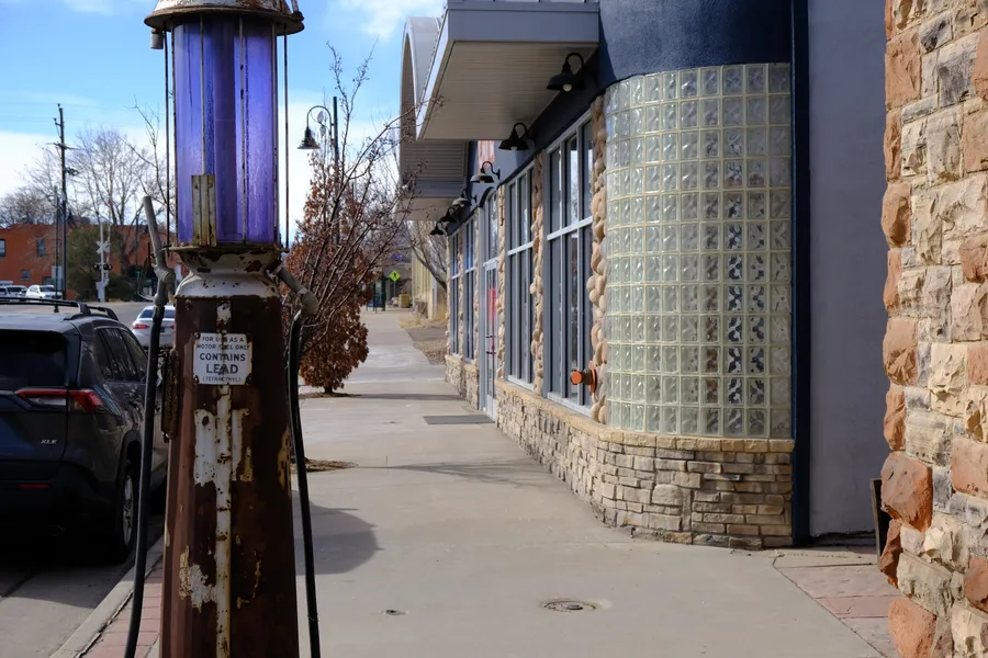 old gas pump along sidewalk