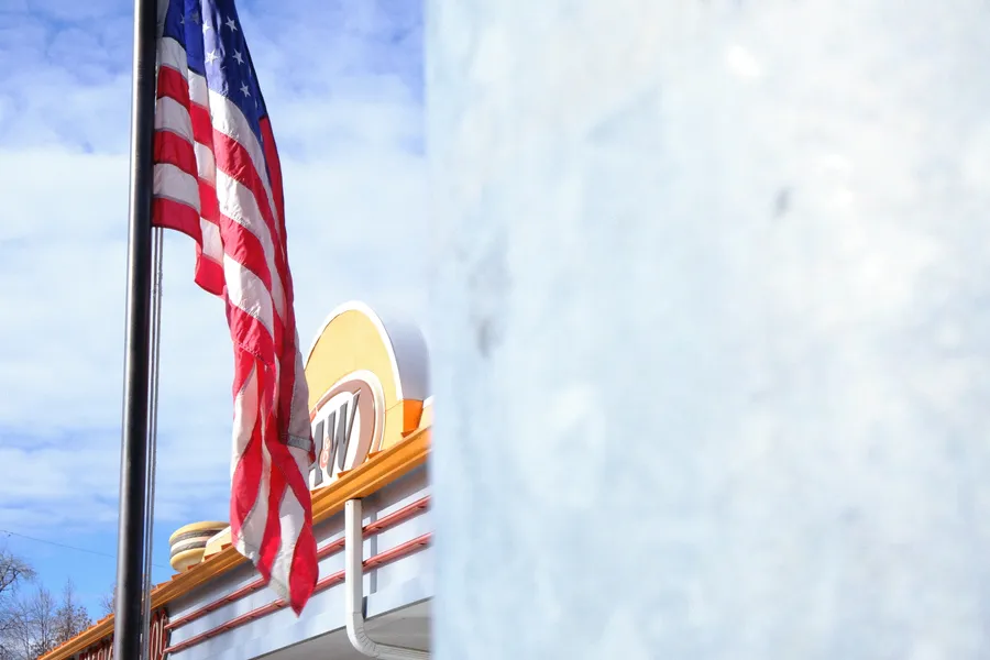flag and a&w resturant behind pole